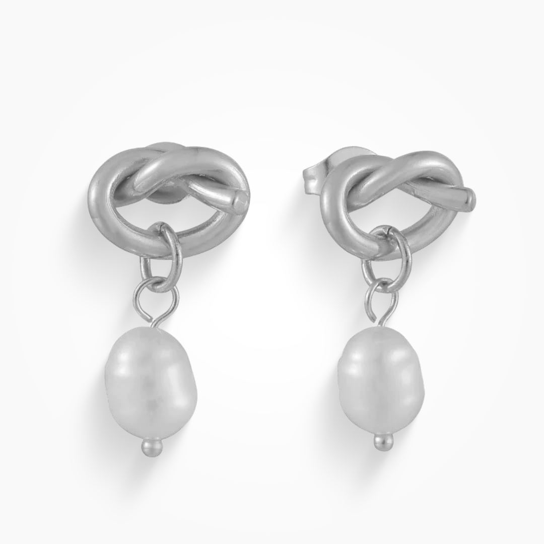 Silver earrings with knot design and pearl charms on a white background